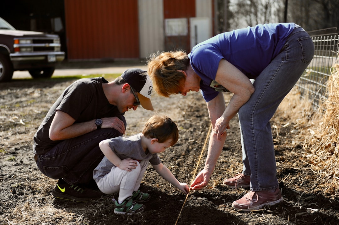 Family with children gardening together, planting seeds in soil